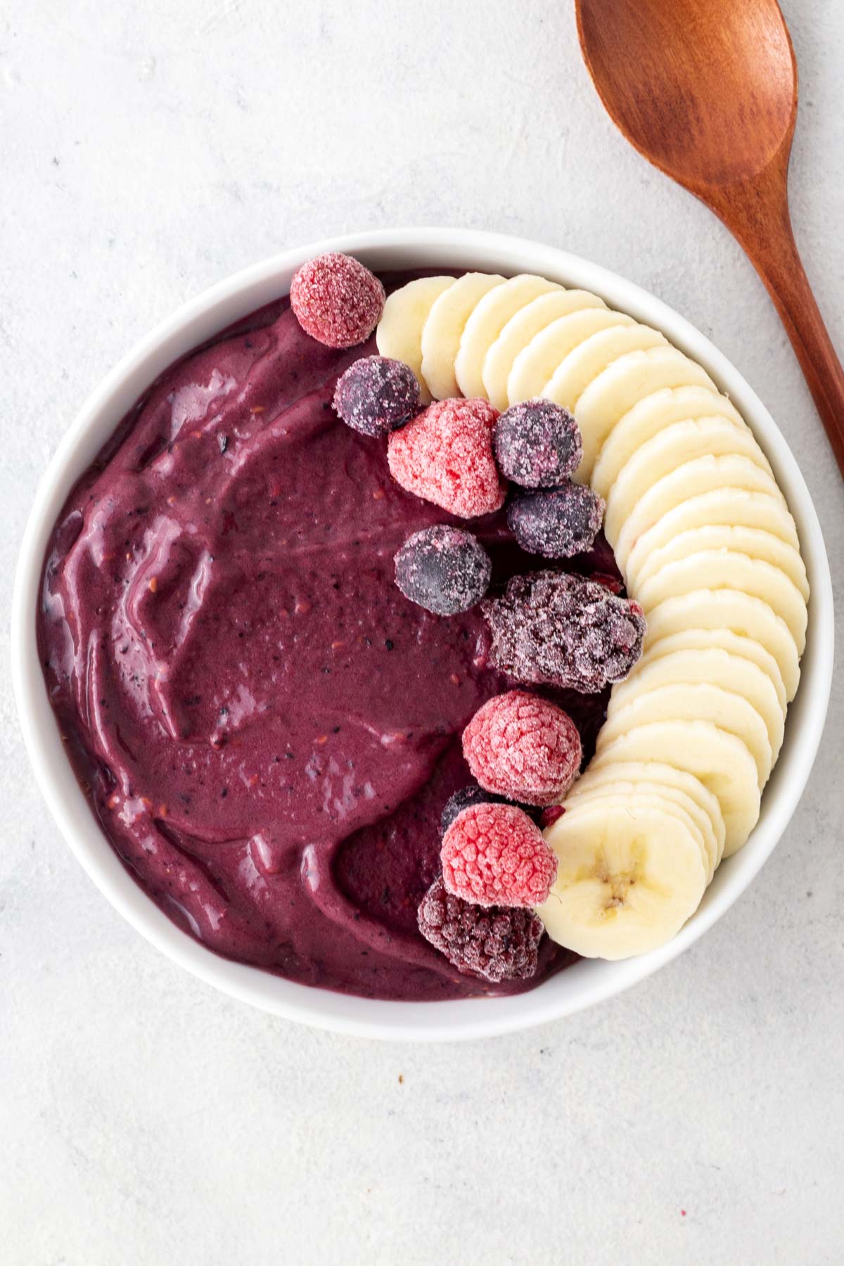 Acai smoothie bowl on a gray table.