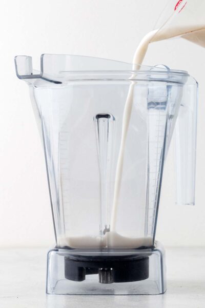 Unsweeted almond milk poured into a blender.