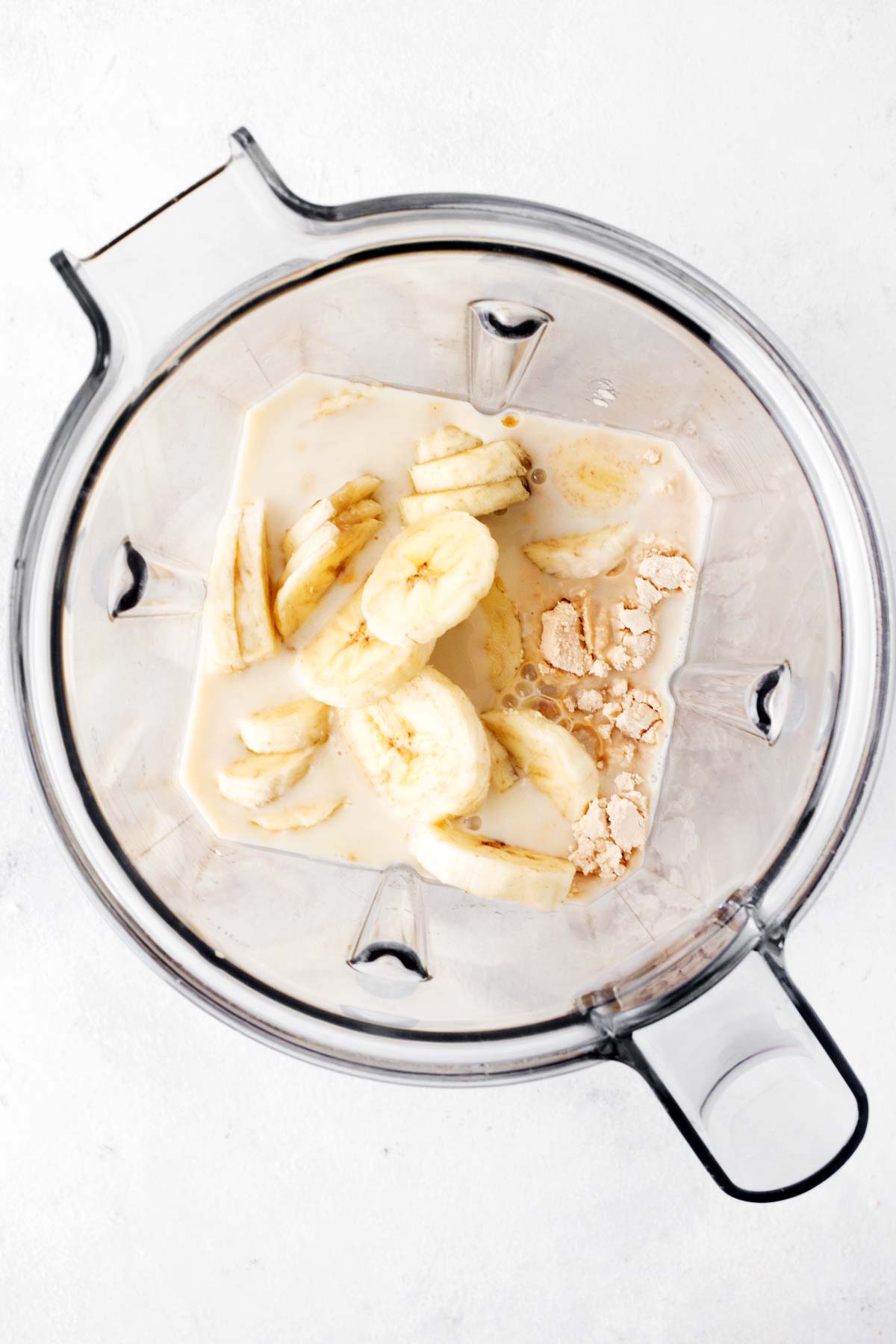 Peanut butter banana protein shake ingredients in a blender.