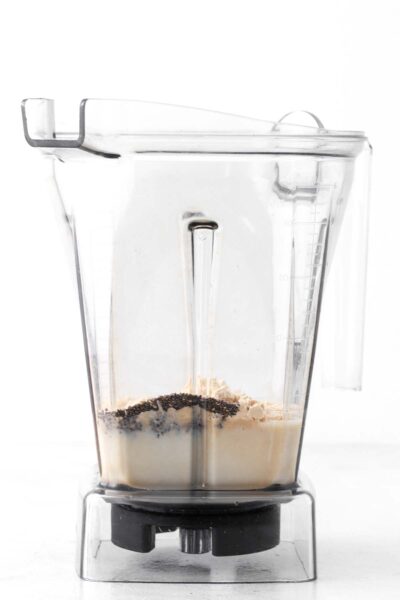 Chia seeds, protein powder and oat milk in a blender.