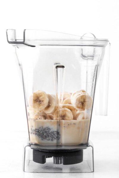 Banana, chia seeds, protein powder and oat milk in a blender.