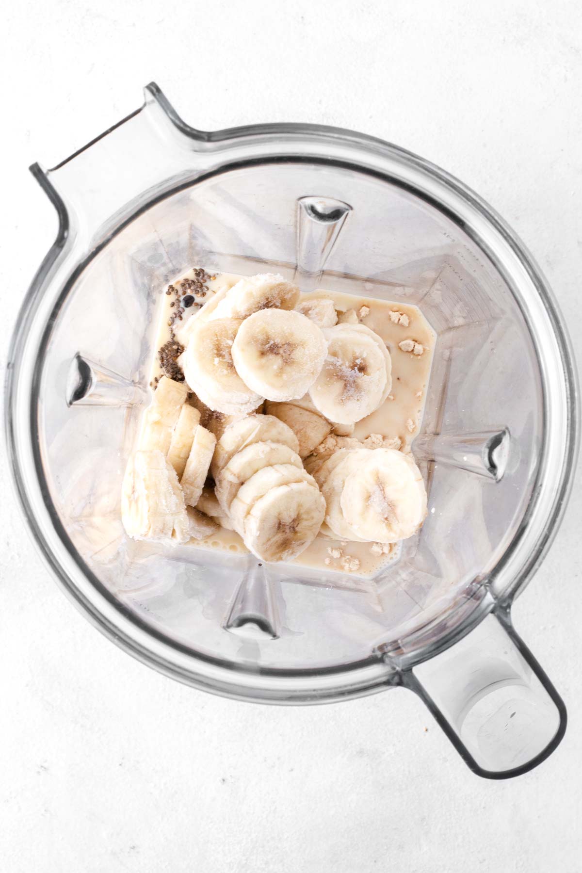 Ingredients for a banana protein smoothie in a blender.