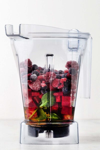 Berries, beets, spinach, and apple juice in a blender.