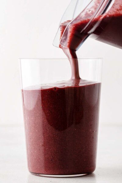 Berry smoothie being poured into a cup.