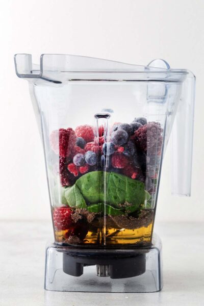 Mixed berries, spinach, and chia seeds, and apple juice in a blender.