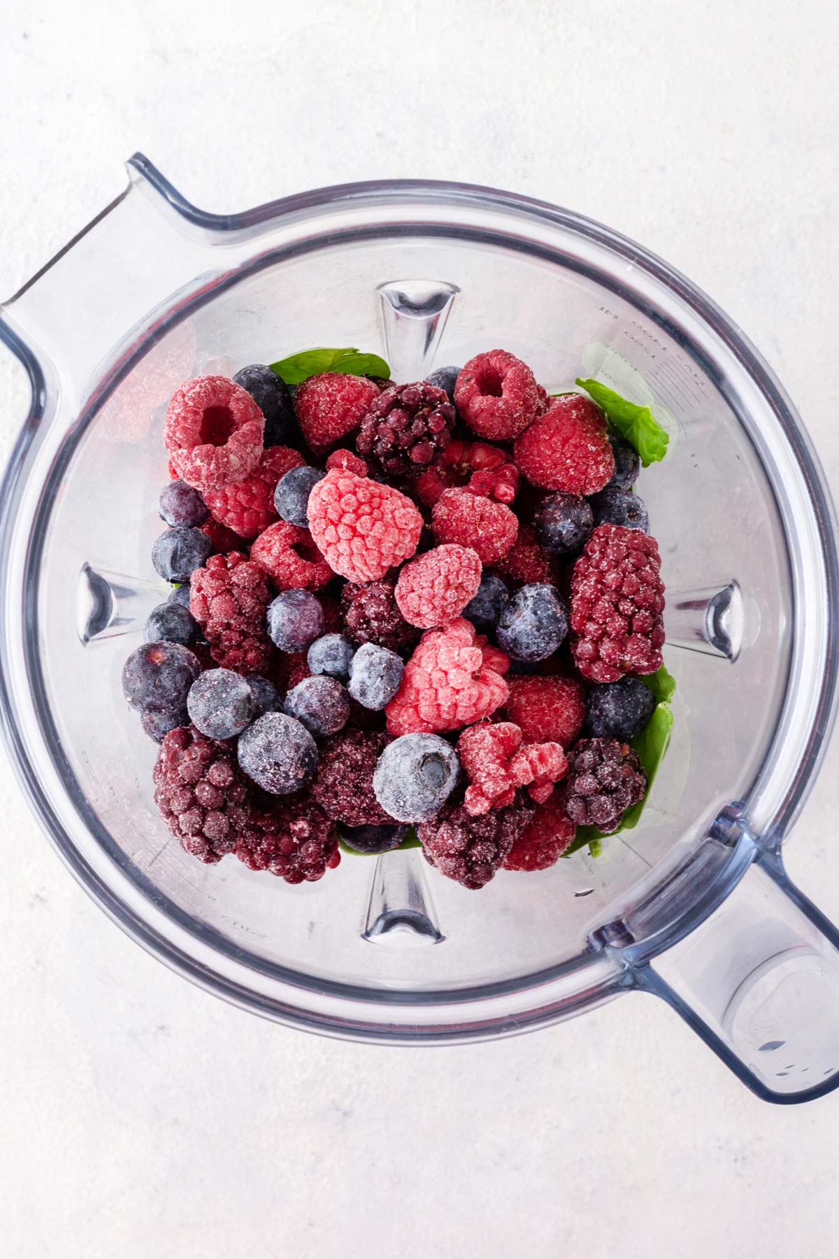 Ingredients for berry smoothie in a blender.
