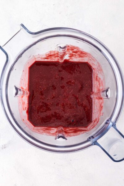 Berry smoothie blended together in blender cup.