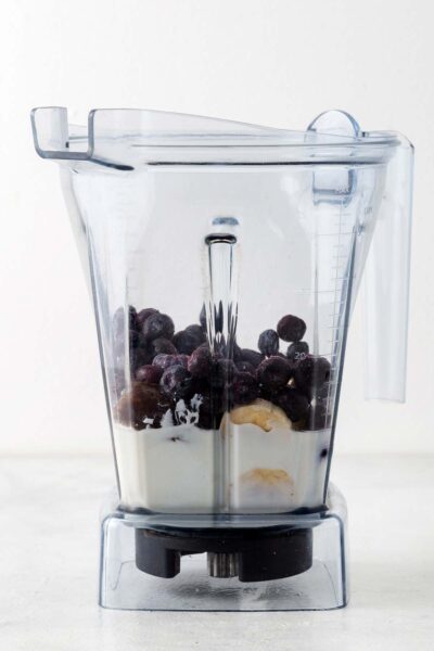 Blueberries, banana, date, yogurt, and milk in a blender. 
