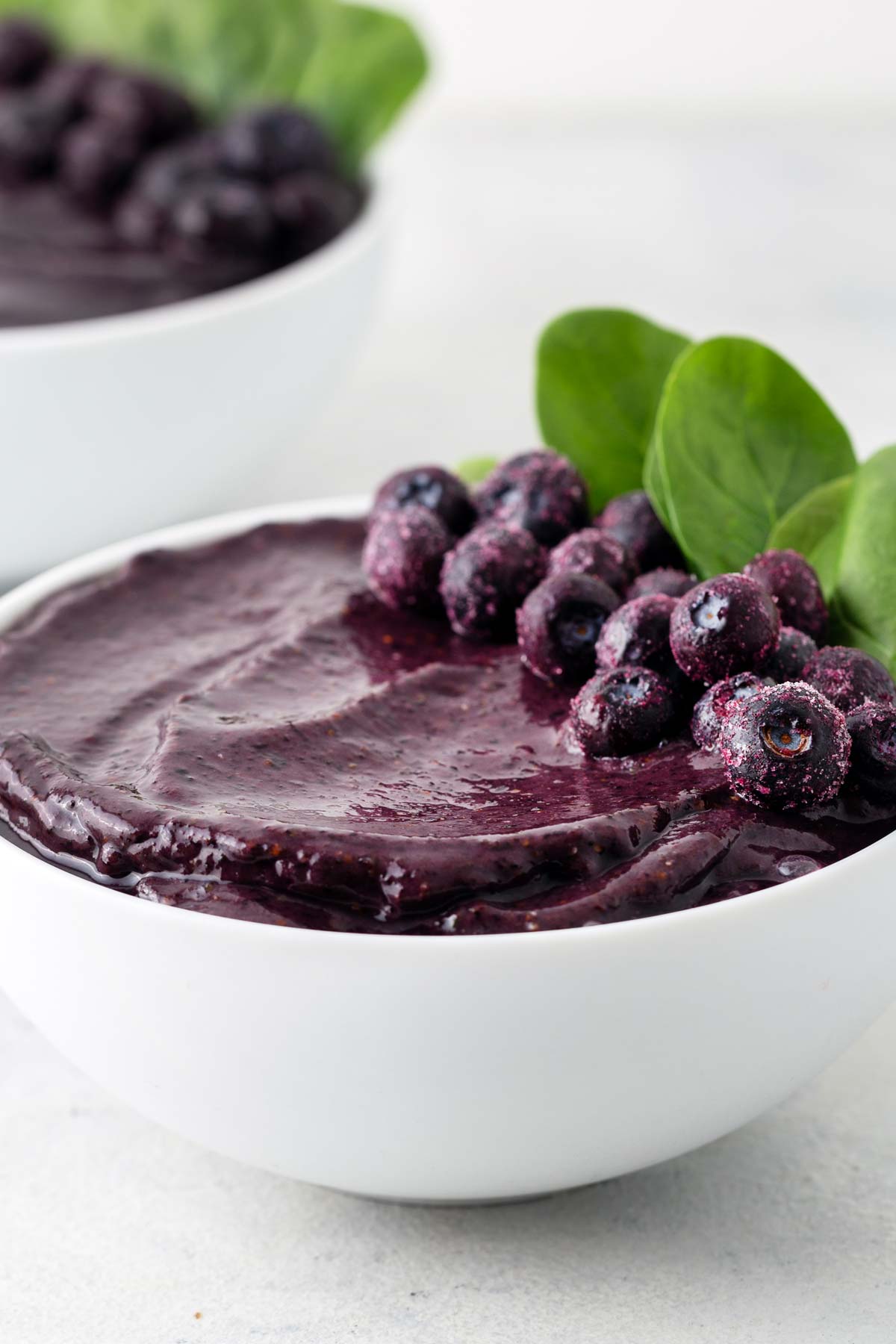 Blueberry smoothie bowl on a gray table.