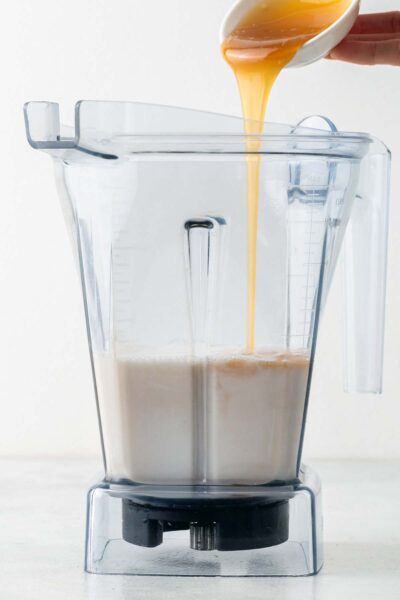 Caramel poured into a blender with vanilla and oat milk. 