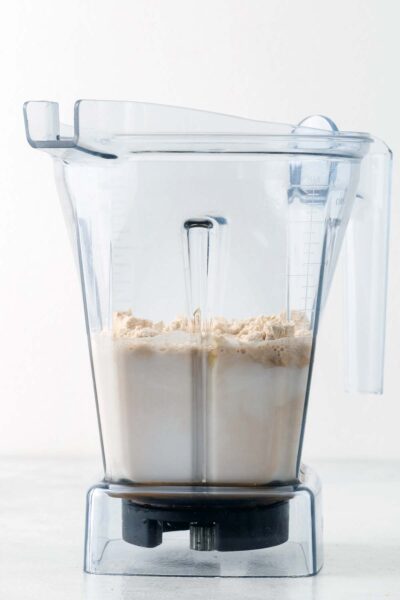 Protein powder, caramel sauce, almond milk, and vanilla extract in a blender. 