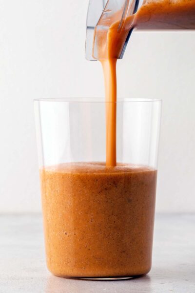 Pouring a smoothie into a cup.