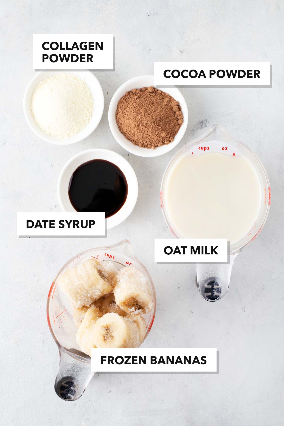 Ingredients for a chocolate collagen smoothie on a gray table.