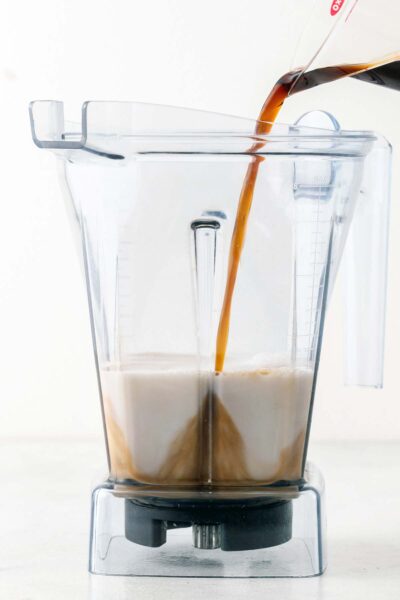 Coffee poured into a blender with almond milk. 