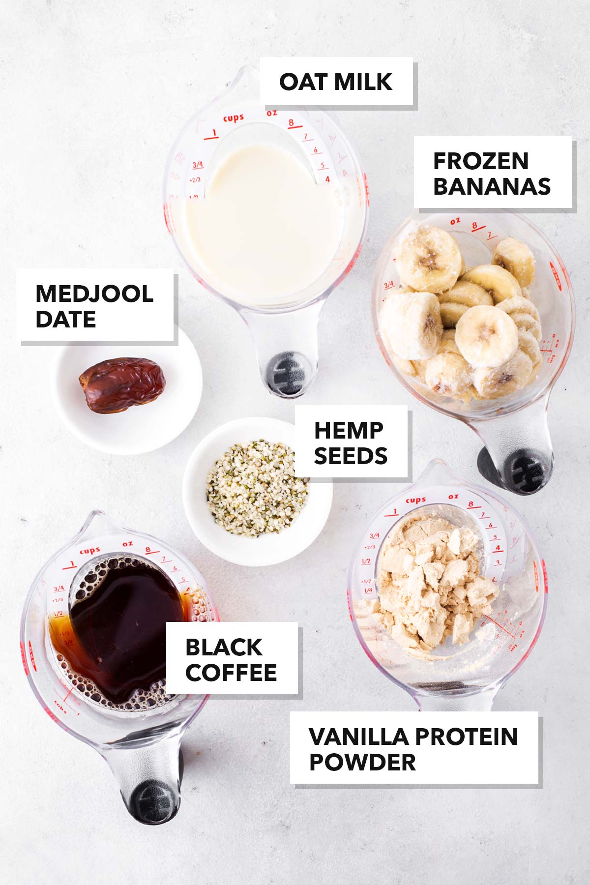 Ingredients to make a coffee protein smoothie on a gray surface.