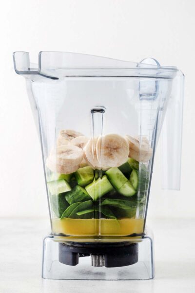Bananas, cucumber, spinach, and pineapple juice in a blender. 