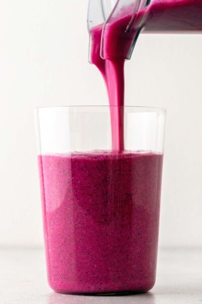 Pink dragon fruit smoothie poured into a cup. 