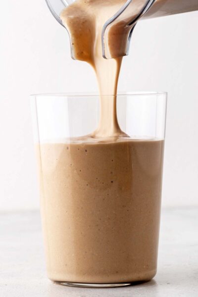 Brown energy smoothie poured into a cup.