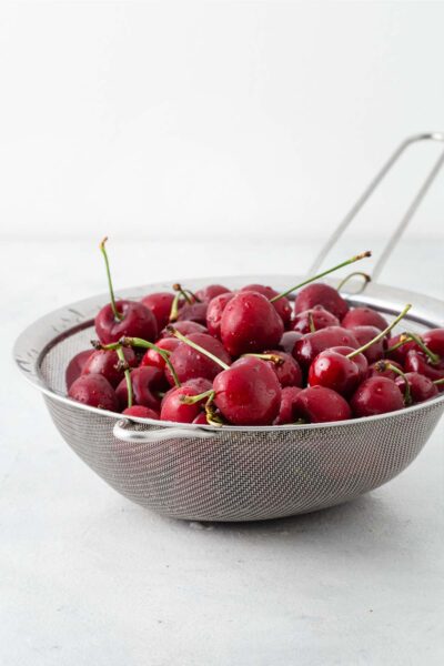 Washed cherries in a colander.