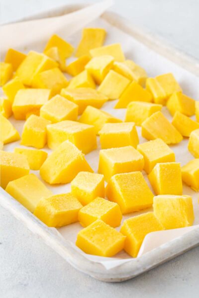 Frozen, cubed mangos on a baking sheet.