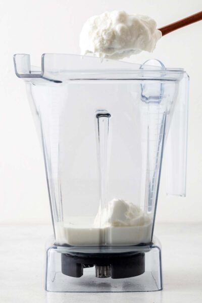 Milk and greek yogurt added to a blender.