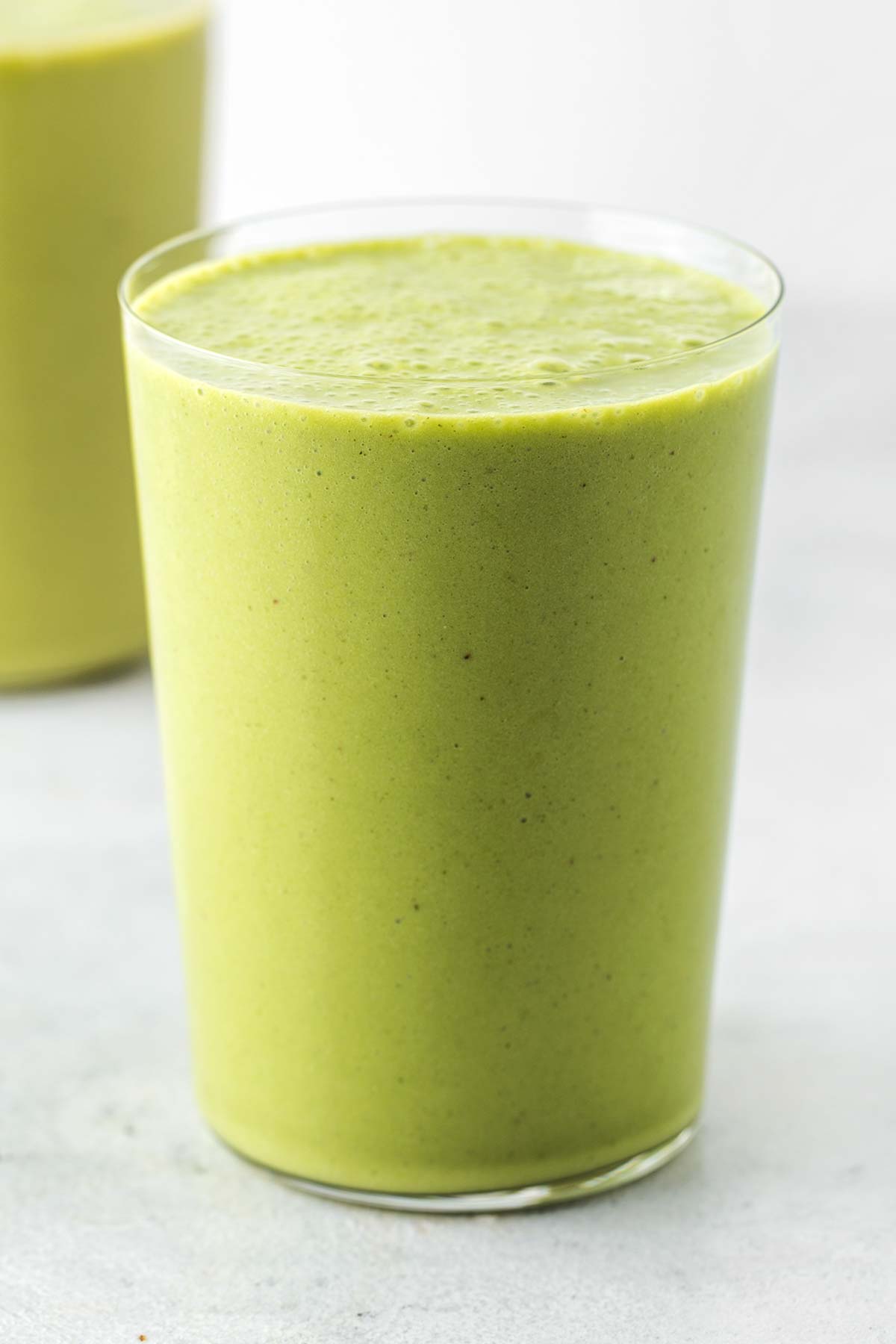 Green protein smoothie in cups.