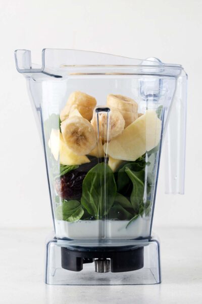 Bananas, dates, apples, spinach and milk in a blender. 