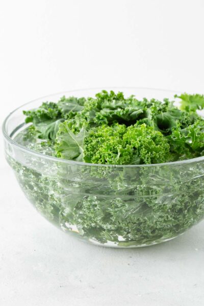 Kale leaves in a bowl of water.