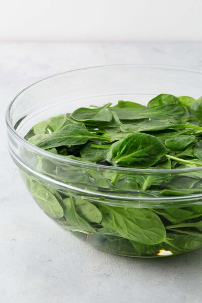 Baby spinach in a bowl of water.