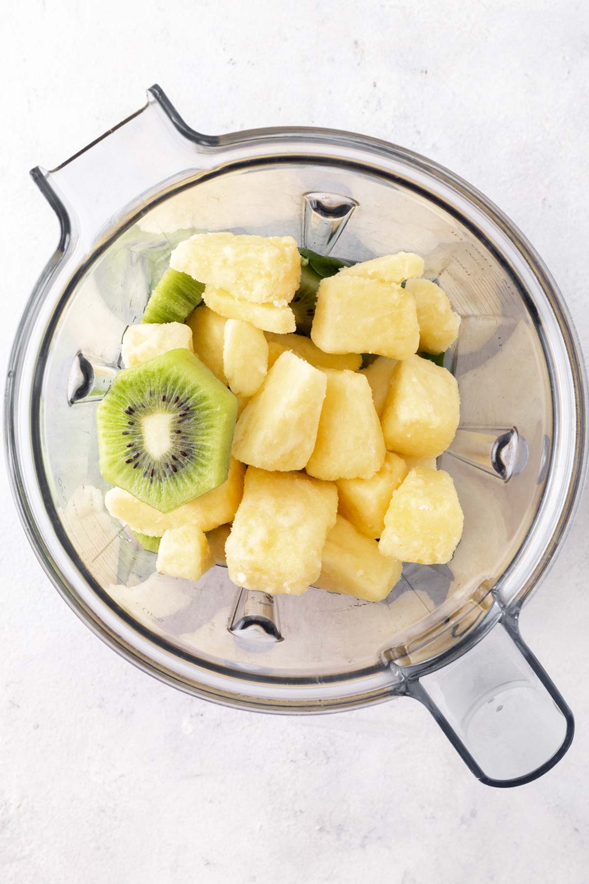 Ingredients for a kiwi smoothie in a blender.