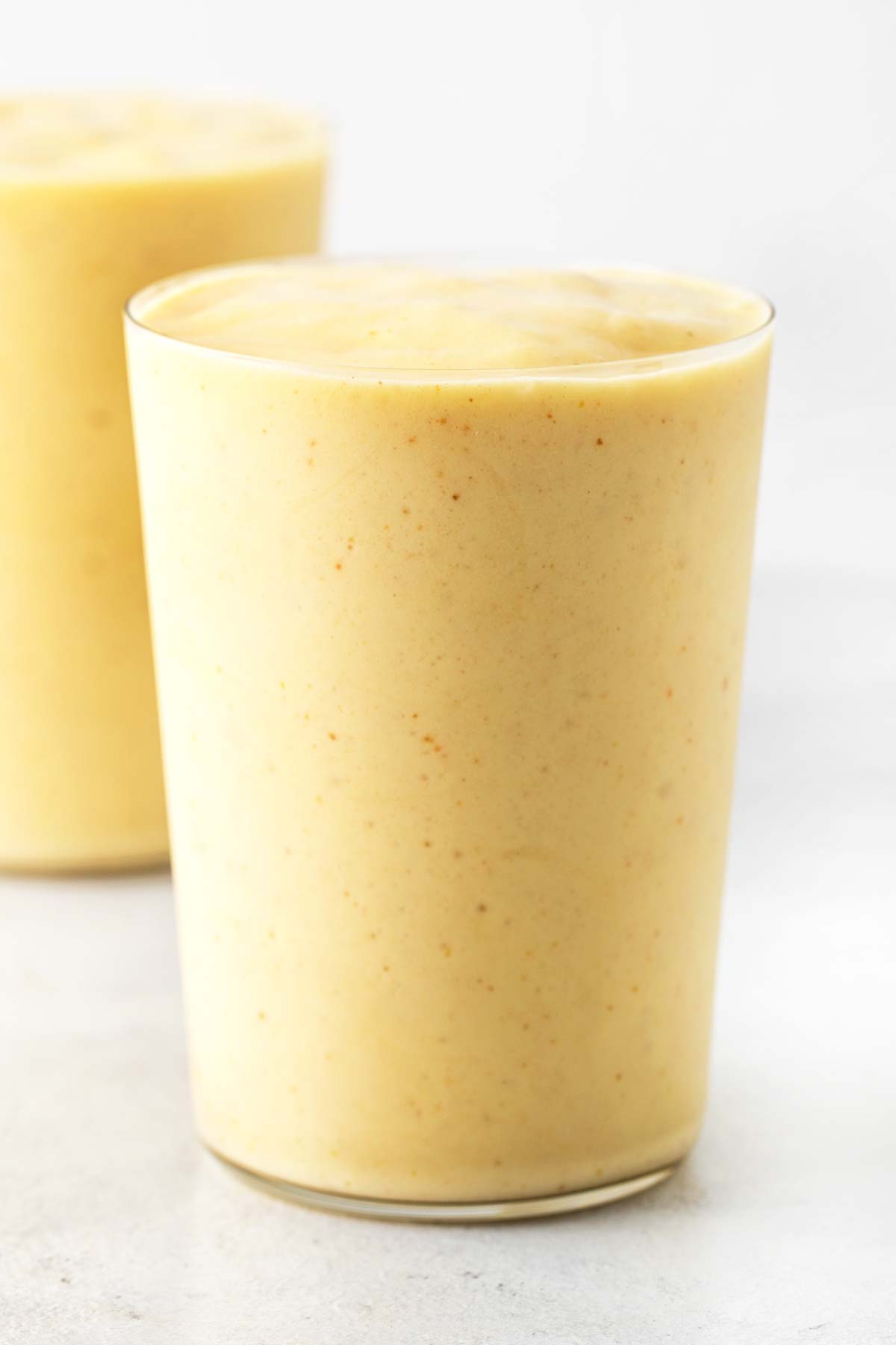 Mango collagen smoothie in a glass.