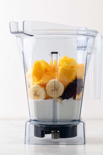 Mango, date, bananas, Greek yogurt, and milk in a blender. 