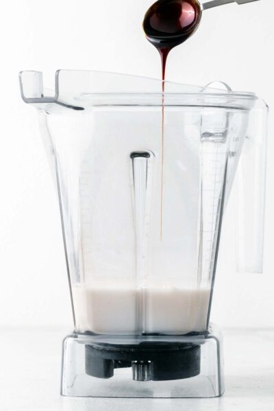 Almond milk and date syrup added to a blender. 