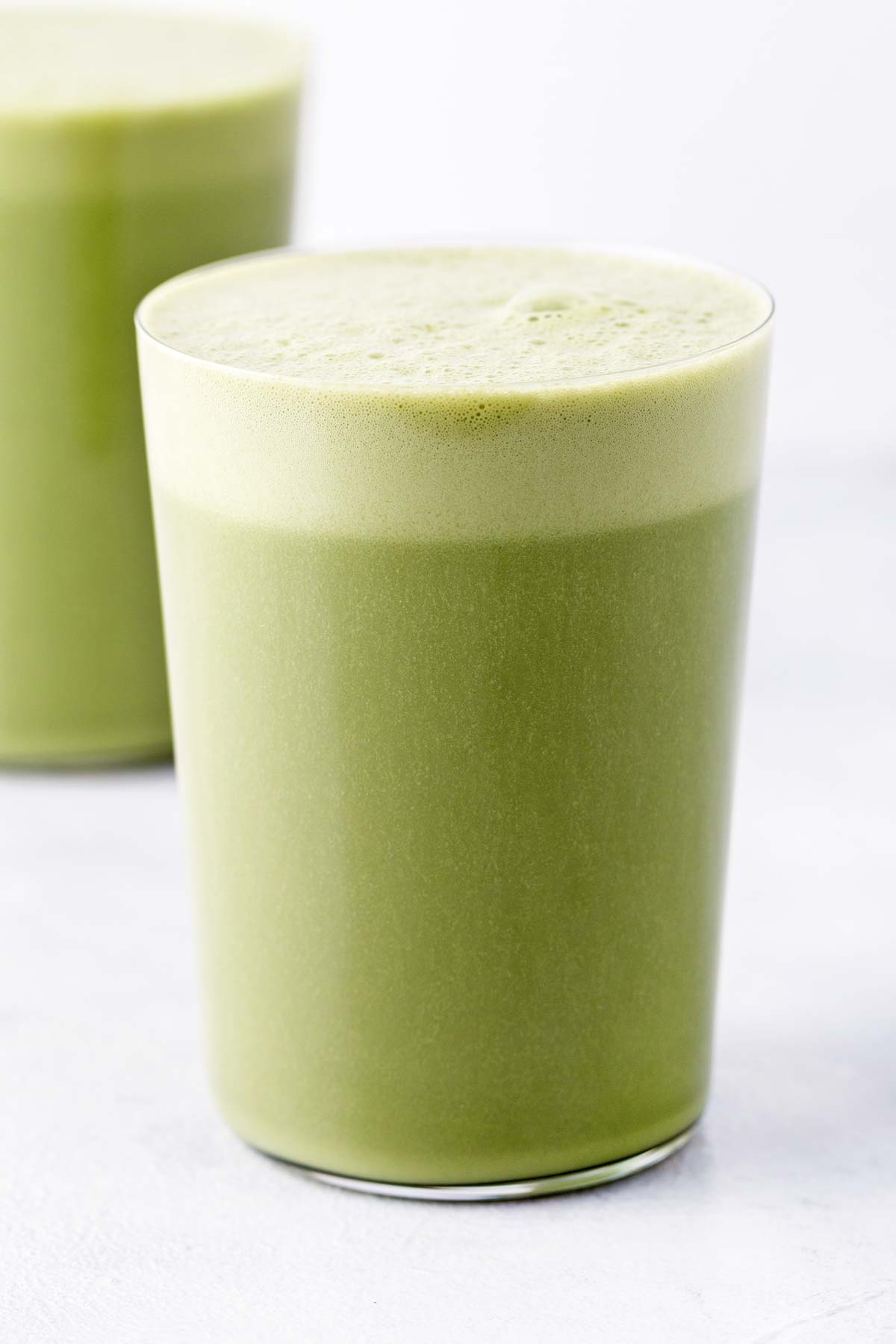 Matcha protein shake in a glass.