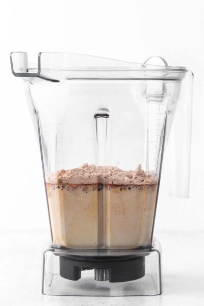 Protein, cocoa powder, espresso, and almond milk in a blender. 