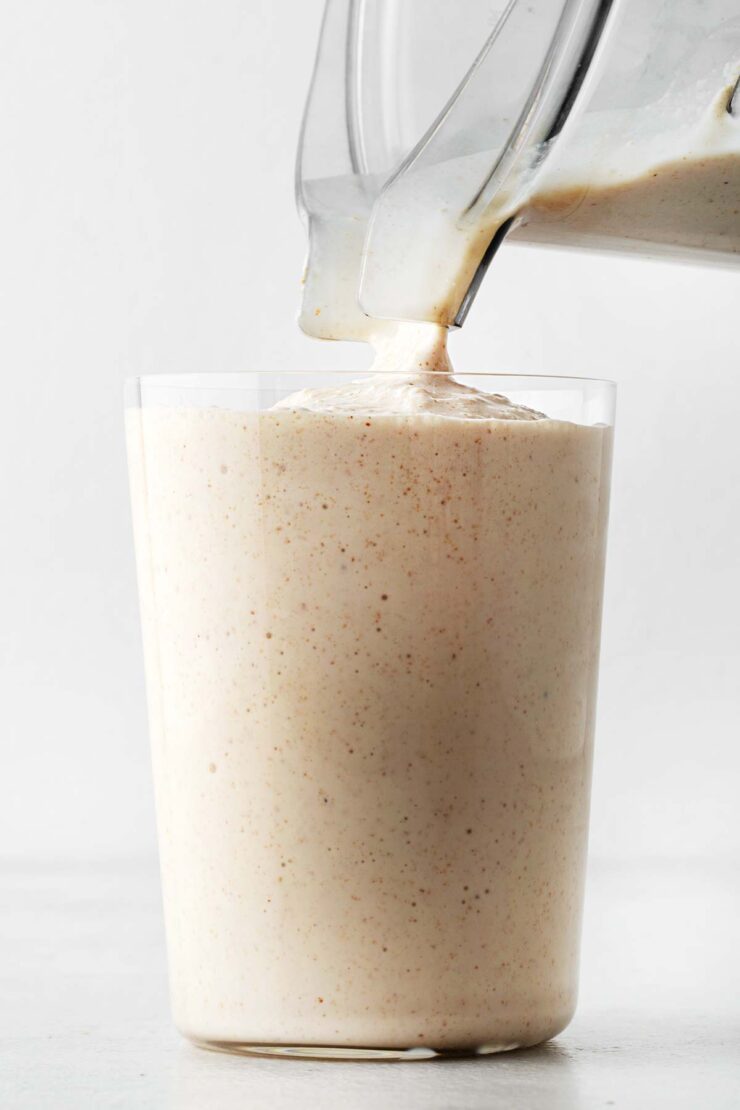 Pouring a peanut butter milkshake in a glass.
