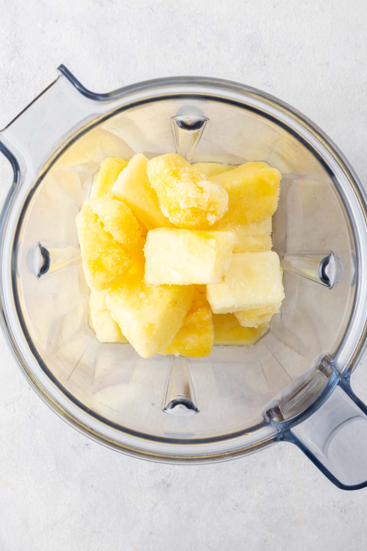 Pineapple smoothie ingredients in a blender.