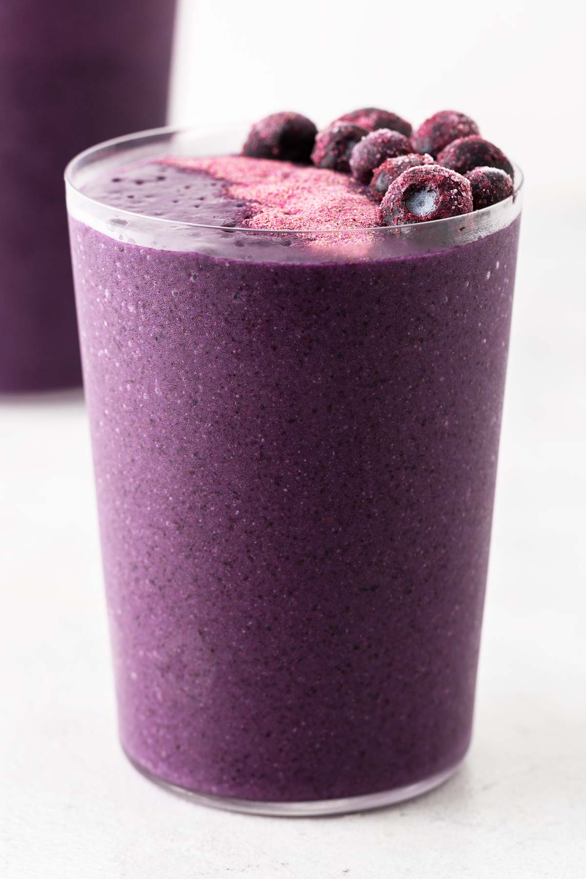 Purple Sweet Potato Smoothie in a glass with frozen blueberry garnish.