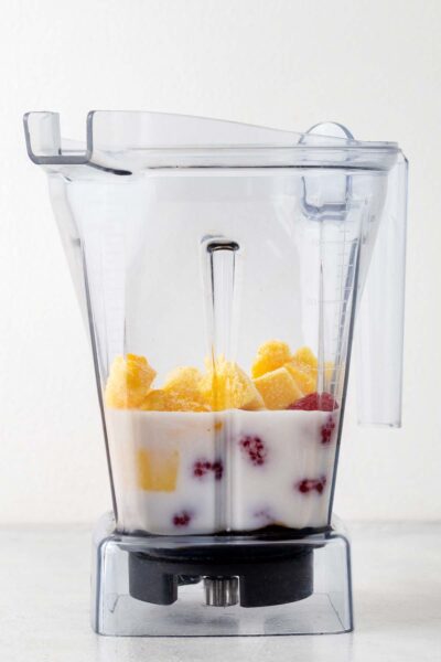 Mango, raspberry, date syrup, almond milk in blender. 