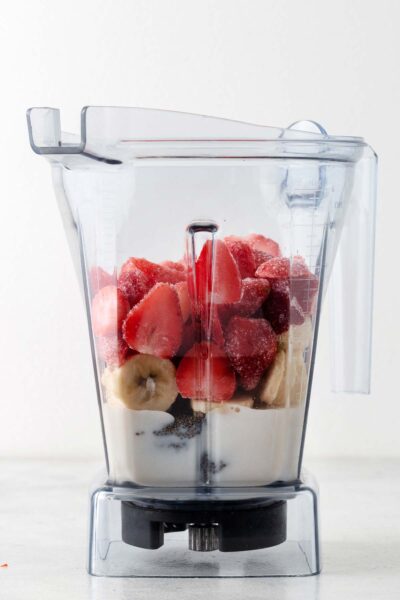 Strawberries, banana, chia seeds and almond milk in a blender. 