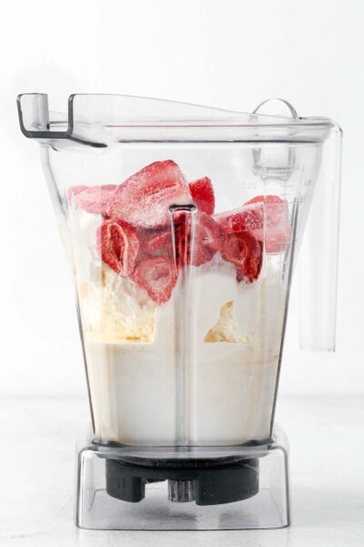 Ingredients for a strawberry milkshake in a blender.