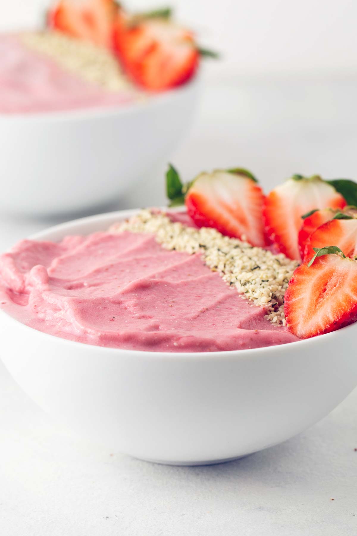 Strawberry protein smoothie bowl on a gray table.