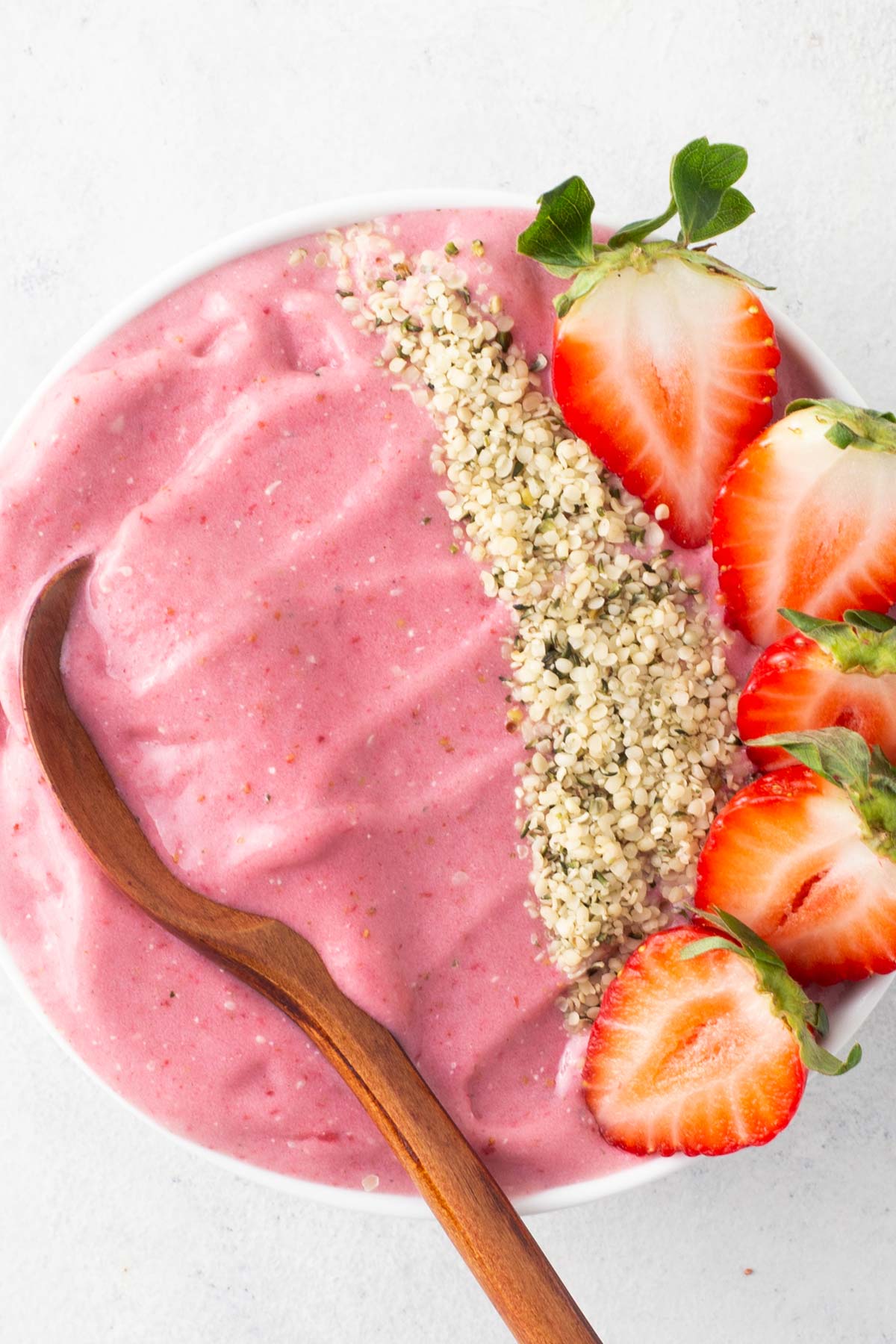 Strawberry protein smoothie bowl on a gray table.