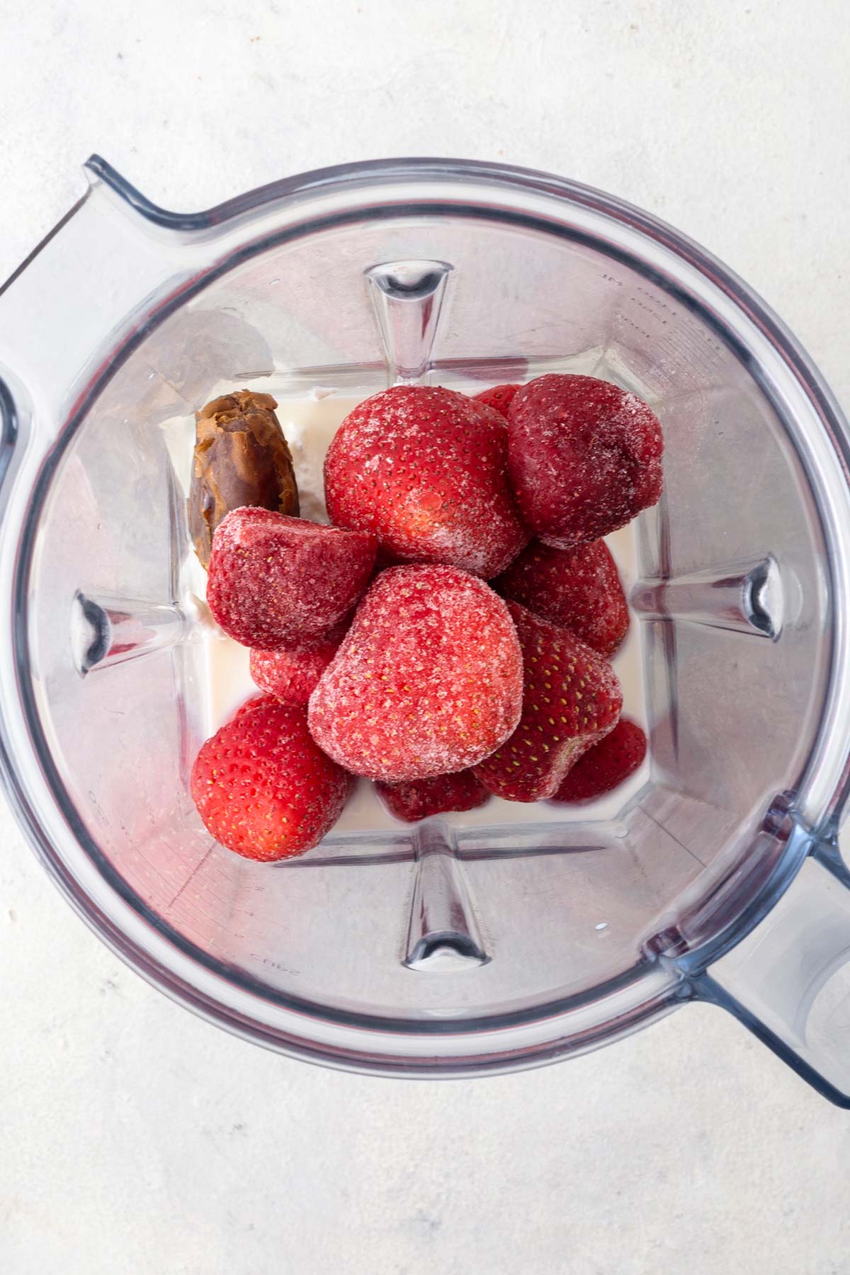 Strawberry smoothie ingredients in a blender.