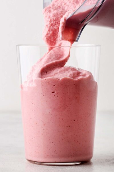 Strawberry smoothie poured into a cup.