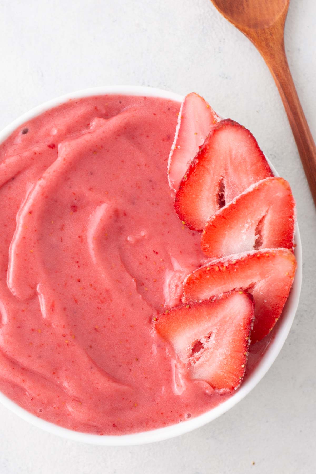 Strawberry smoothie bowl garnished with sliced strawberries.