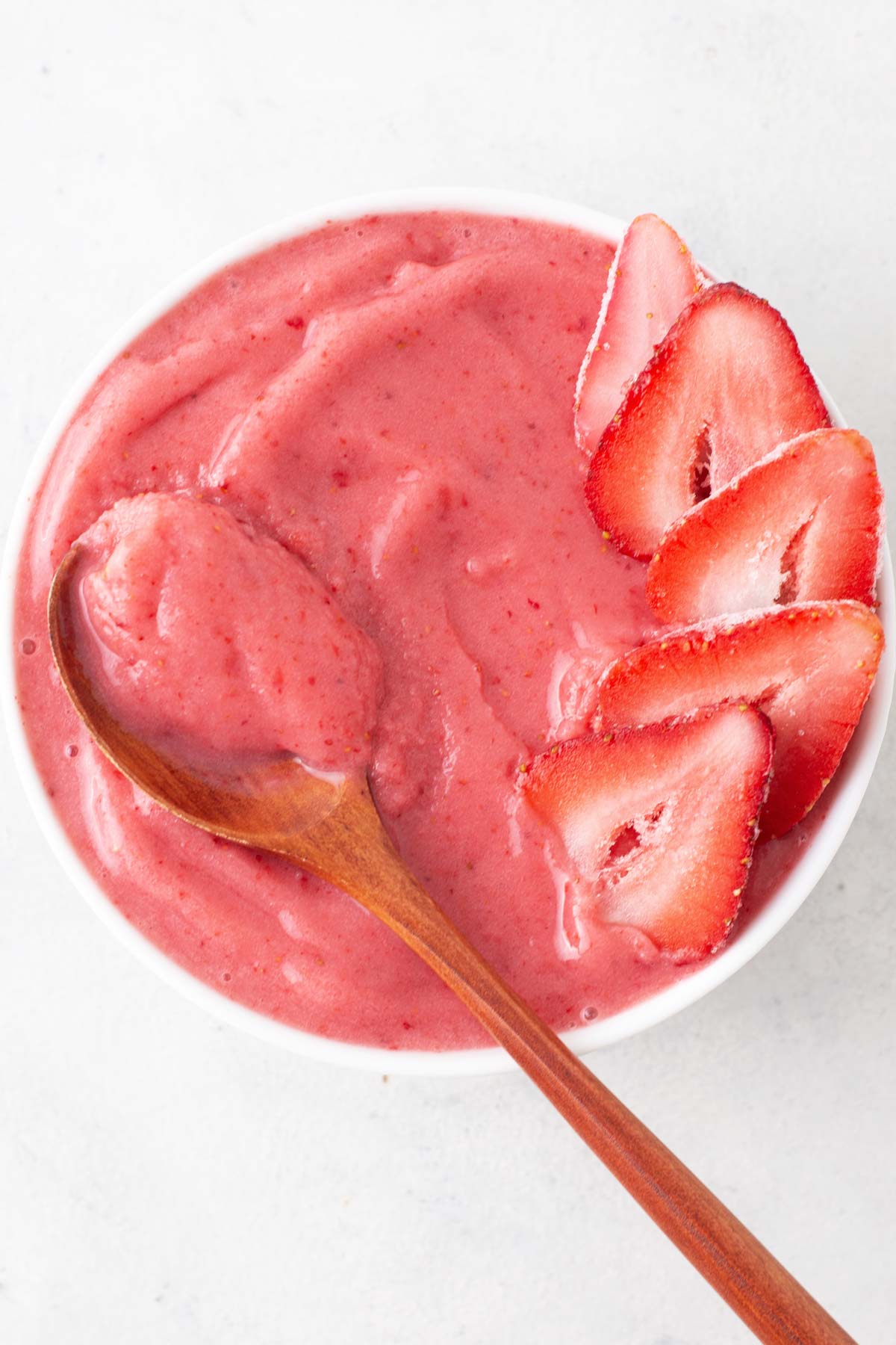 Spoon in a strawberry smoothie bowl.
