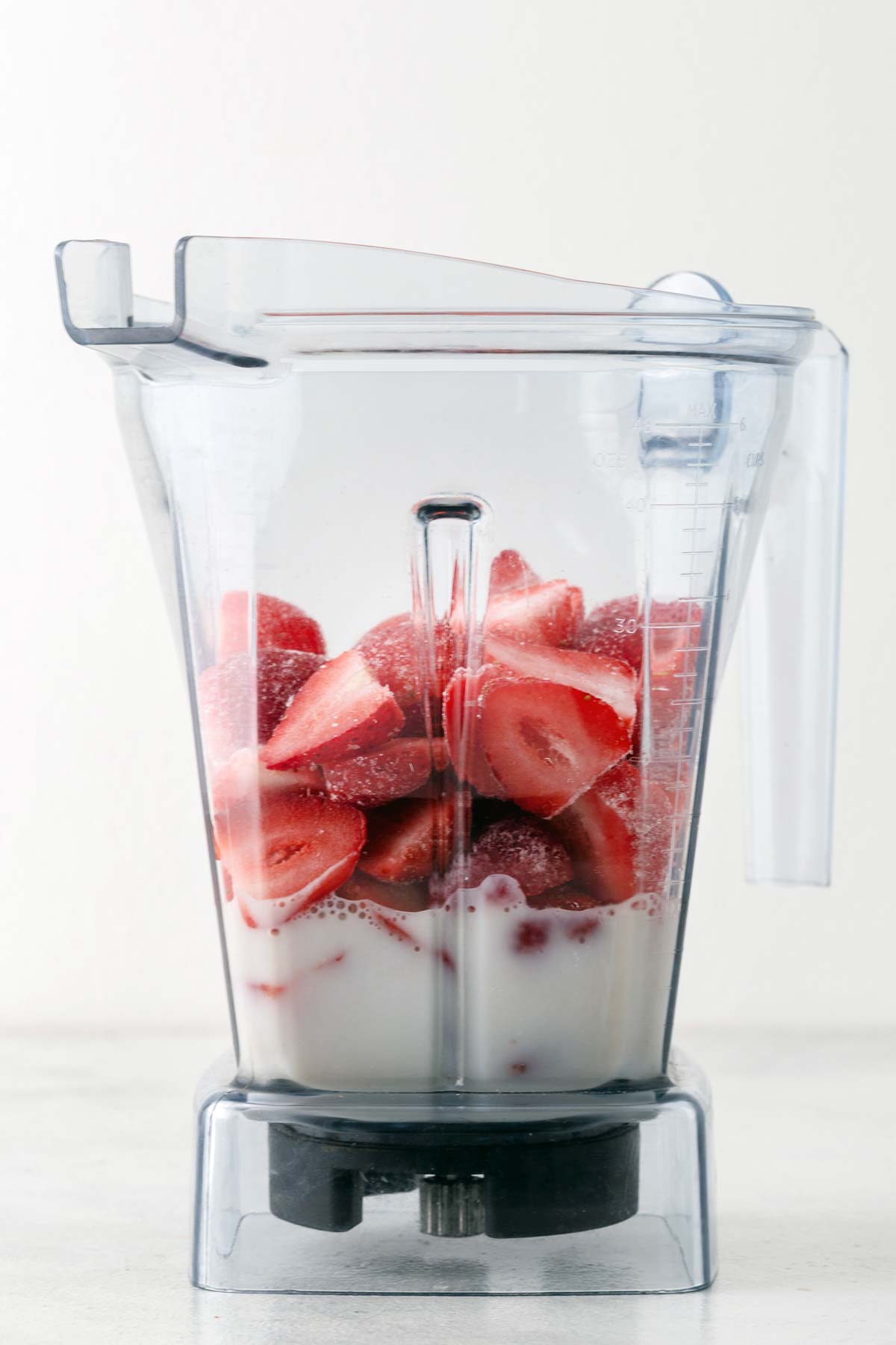 Ingredients for a strawberry smoothie bowl in a blender.